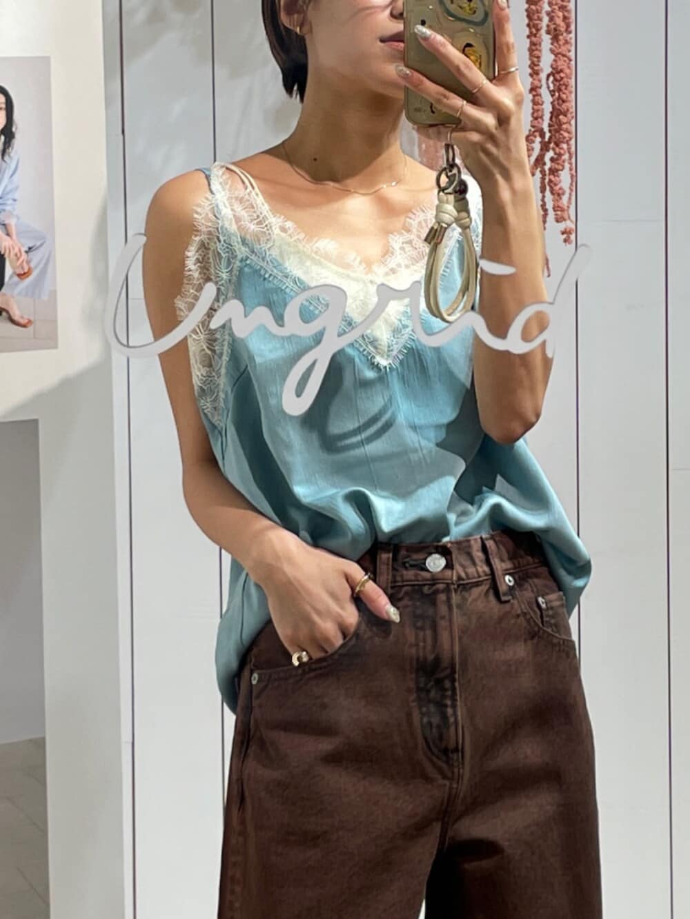 ブルー系のキャミソール、ブラウン系のデニムパンツを着用したレディースの冬コーディネートの2枚目の写真