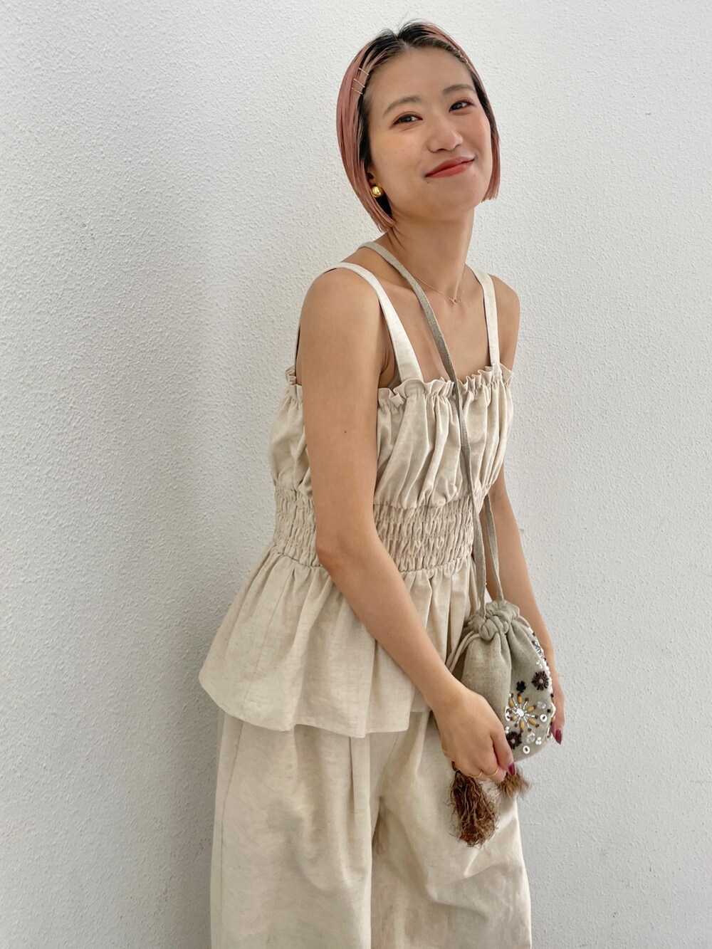 ホワイト系のキャミソール、ホワイト系のその他パンツ、ブラック系のハンドバッグを着用したレディースの夏コーディネートの3枚目の写真