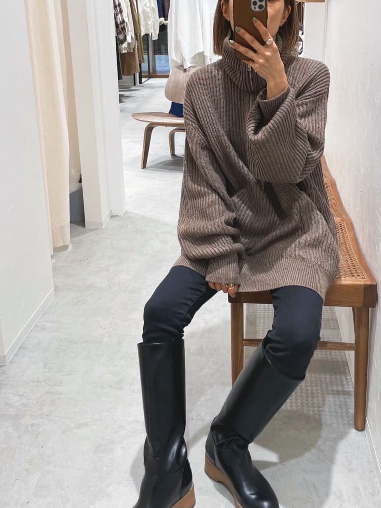 ブラック系のデニムパンツ、ブラウン系のニット/セーターを着用したレディースの秋コーディネートの2枚目の写真