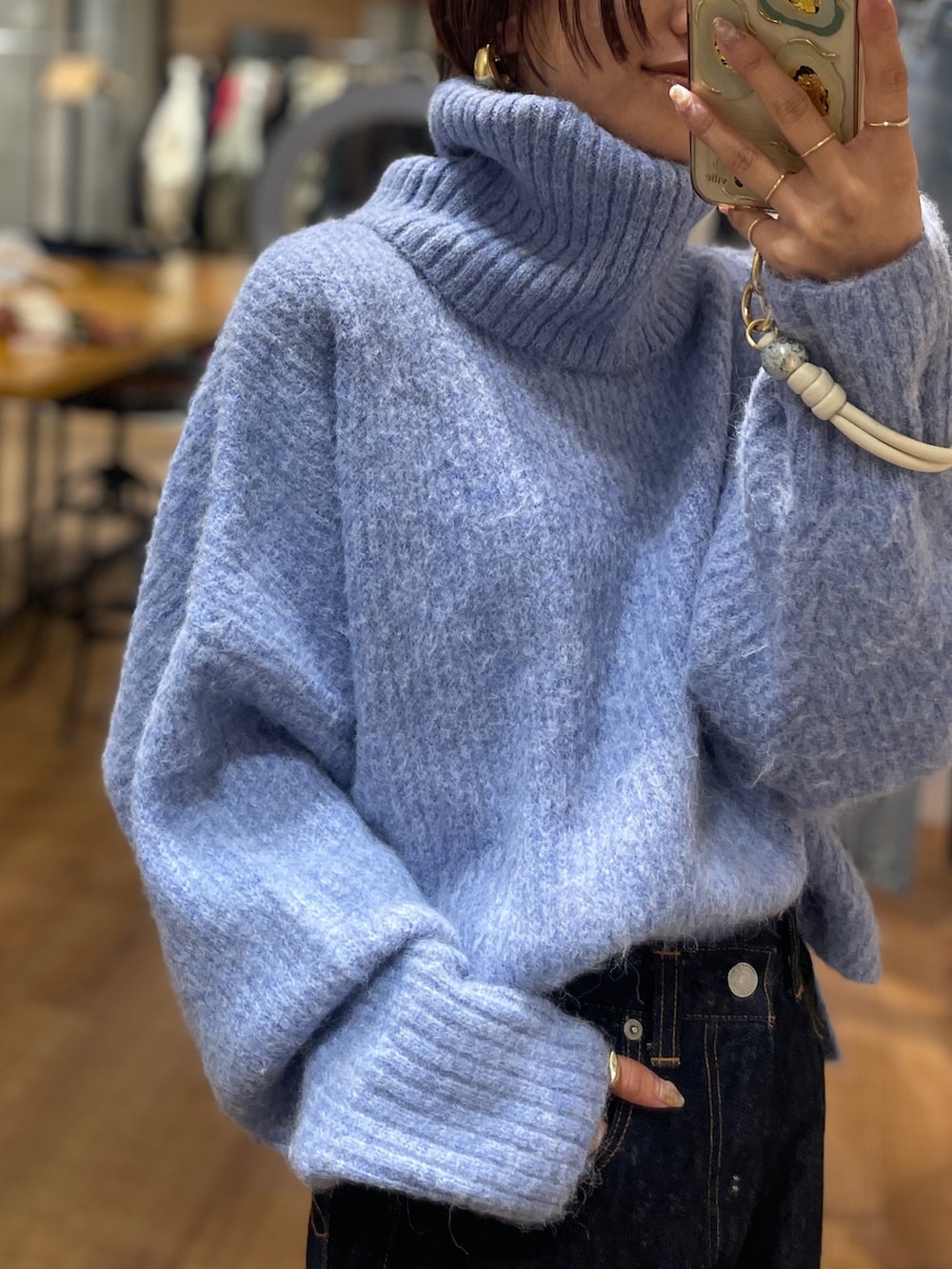 ブルー系のニット/セーター、ブルー系のデニムパンツを着用したレディースの冬コーディネートの3枚目の写真