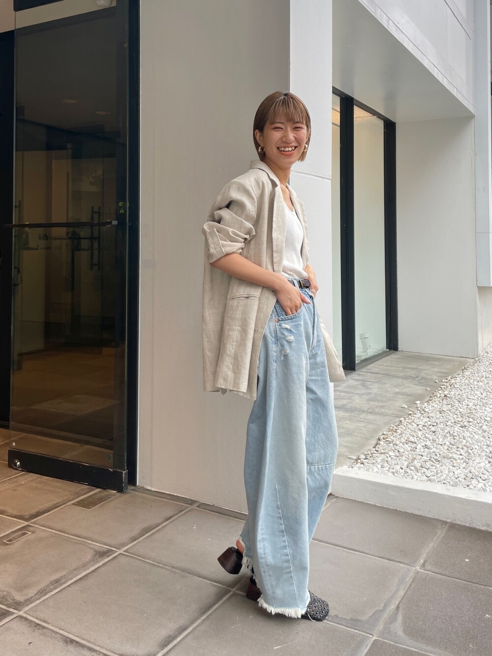 ベージュ系のテーラードジャケット、ホワイト系のタンクトップを着用したレディースの春コーディネートの8枚目の写真