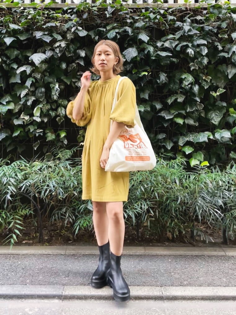 ブラック系のブーツ、イエロー系のエコバッグ/サブバッグ、グリーン系のワンピースを着用したレディースの春コーディネートの4枚目の写真