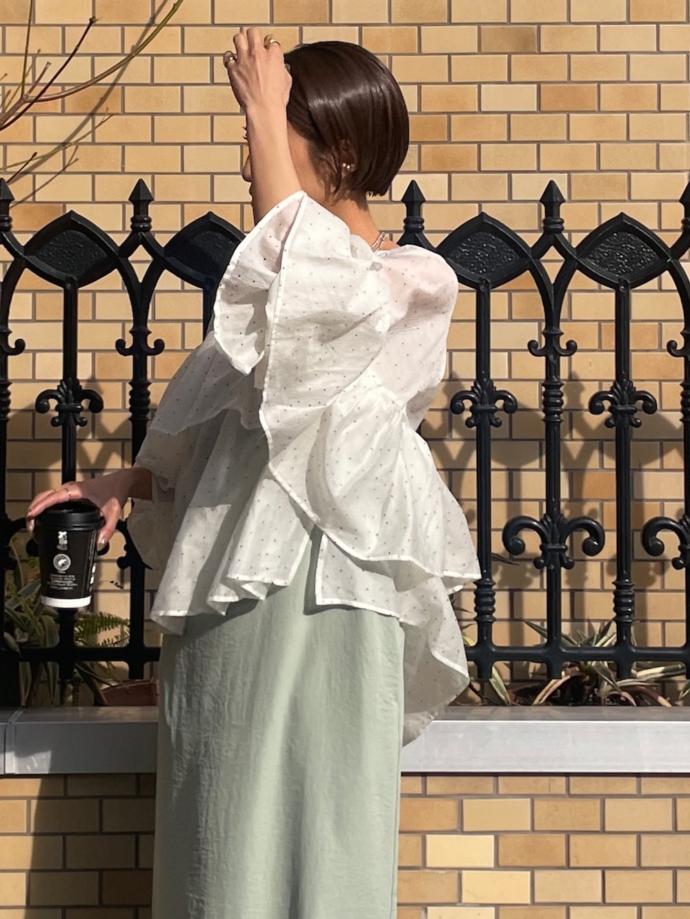 グリーン系のワンピース、その他のシャツ/ブラウス、ホワイト系のパンプスを着用したレディースの春コーディネートの6枚目の写真