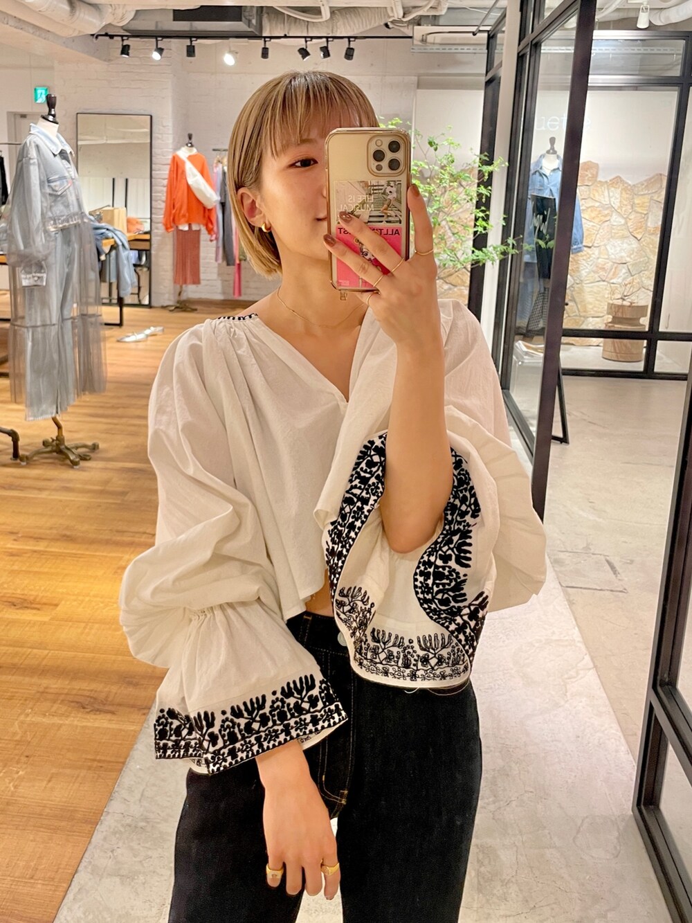 ブルー系のデニムパンツ、ブラック系のブーツ、ホワイト系のシャツ/ブラウスを着用したレディースの春コーディネートの3枚目の写真
