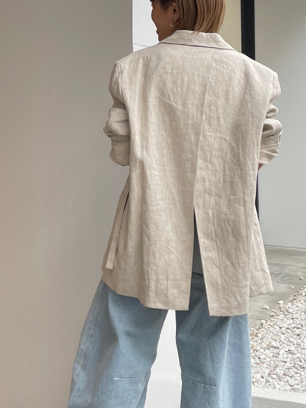 ベージュ系のテーラードジャケット、ホワイト系のタンクトップを着用したレディースの春コーディネートの7枚目の写真