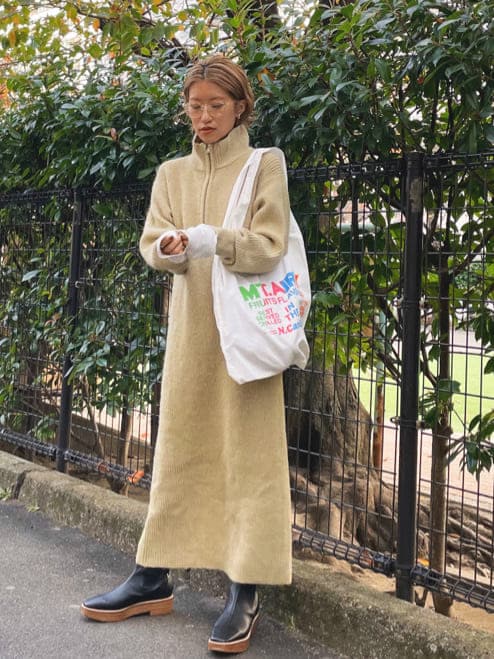 ブラウン系のブルゾン、グリーン系のワンピース、ホワイト系のエコバッグ/サブバッグを着用したレディースの冬コーディネートの2枚目の写真