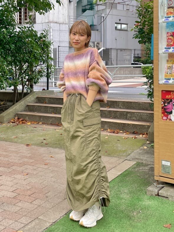 グリーン系のスカート、ピンク系のニット/セーターを着用したレディースの秋コーディネートの5枚目の写真