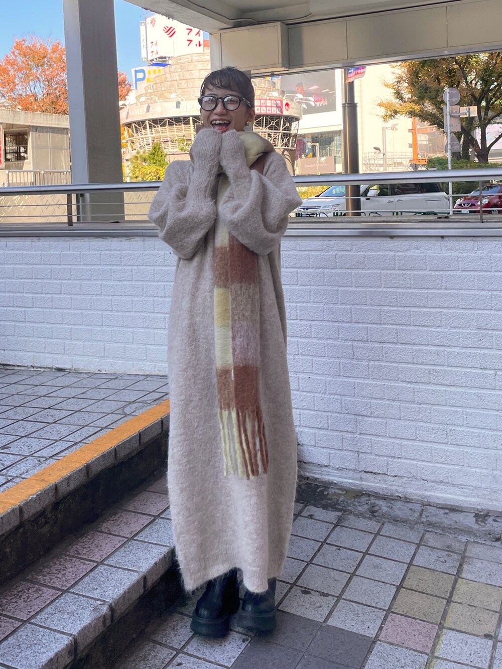 ホワイト系のワンピース、ブラウン系のマフラーを着用したレディースの秋コーディネートの2枚目の写真