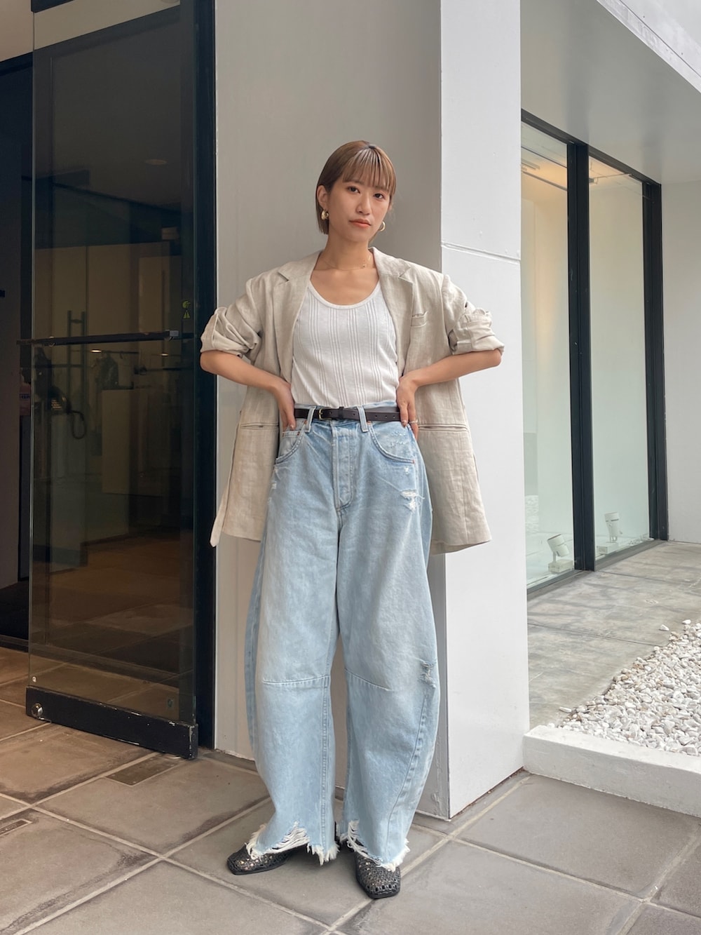 ベージュ系のテーラードジャケット、ホワイト系のタンクトップを着用したレディースの春コーディネートの5枚目の写真