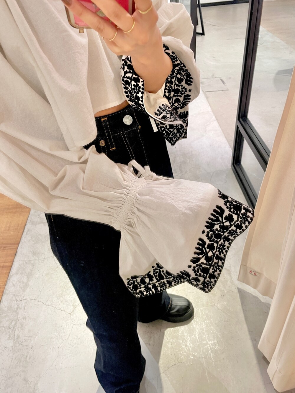 ブルー系のデニムパンツ、ブラック系のブーツ、ホワイト系のシャツ/ブラウスを着用したレディースの春コーディネートの6枚目の写真