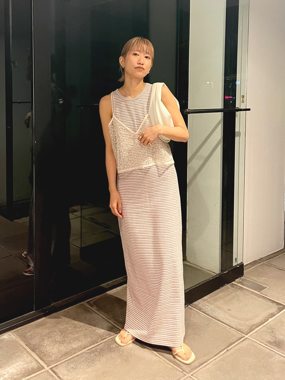 ホワイト系のワンピース、ホワイト系のキャミソール、ホワイト系のハンドバッグを着用したレディースの春コーディネートの2枚目の写真