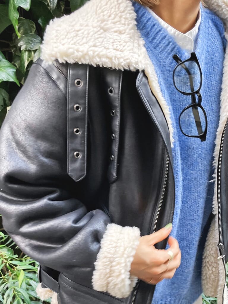 ブルー系のニット/セーター、ブラック系のブーツ、ブラック系のブルゾンを着用したレディースの秋コーディネートの4枚目の写真