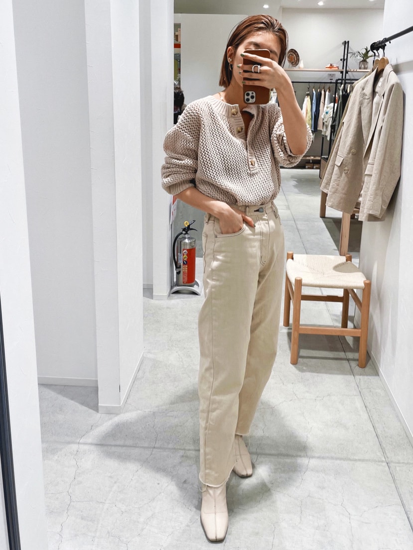 ホワイト系のデニムパンツ、ホワイト系のニット/セーター、ゴールド系のネックレスを着用したレディースの春コーディネートの3枚目の写真