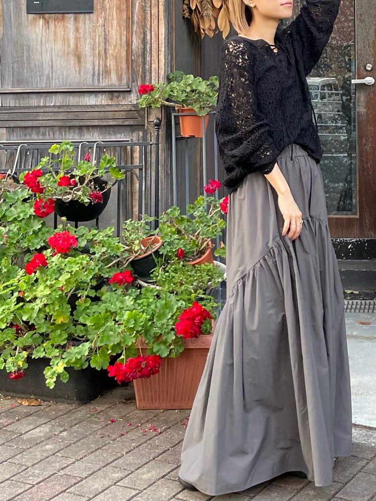 グレー系のスカート、ブラック系のニット/セーターを着用したレディースの冬コーディネートの2枚目の写真