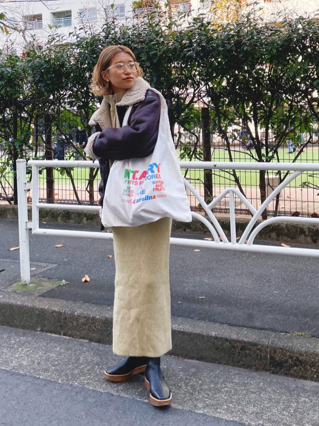 ブラウン系のブルゾン、グリーン系のワンピース、ホワイト系のエコバッグ/サブバッグを着用したレディースの冬コーディネートの5枚目の写真