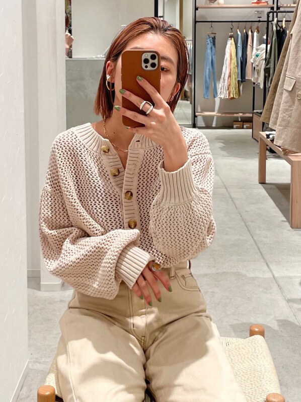 ホワイト系のデニムパンツ、ホワイト系のニット/セーター、ゴールド系のネックレスを着用したレディースの春コーディネートの2枚目の写真