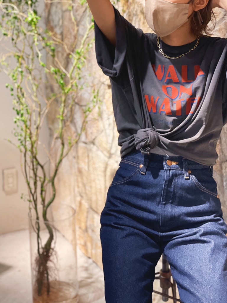 ブルー系のデニムパンツ、ブラック系のサンダル、グレー系のTシャツ/カットソーを着用したレディースの春コーディネートの2枚目の写真