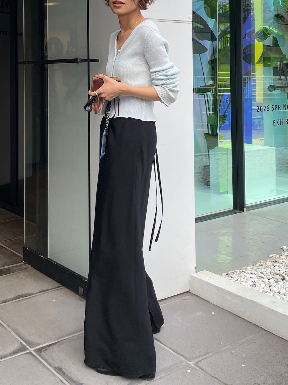 ブルー系のカーディガン/ボレロ、ブラック系のスカートを着用したレディースの春コーディネートの3枚目の写真