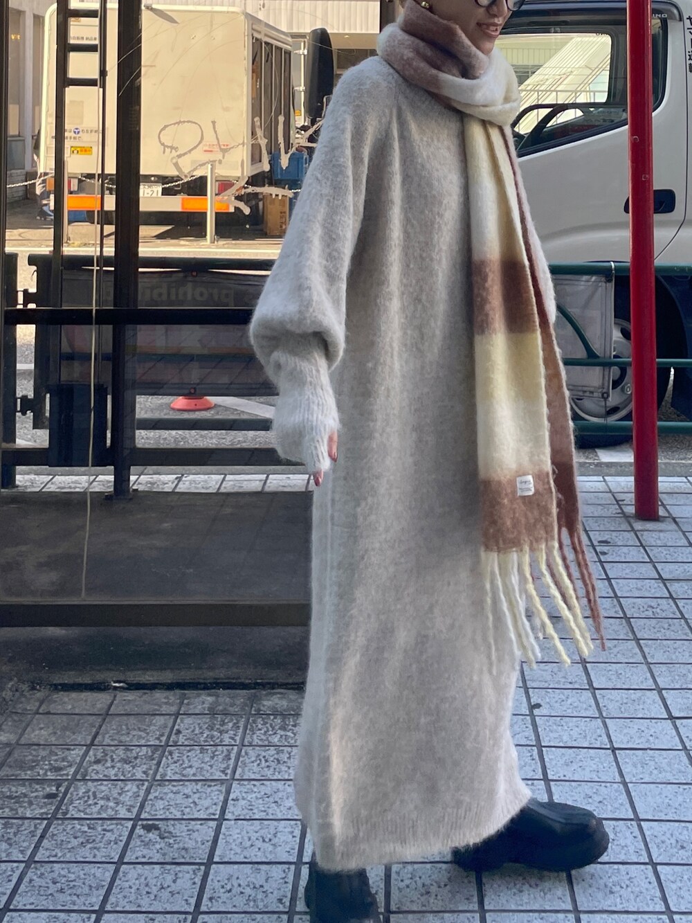 ホワイト系のワンピース、ブラウン系のマフラーを着用したレディースの秋コーディネートの3枚目の写真