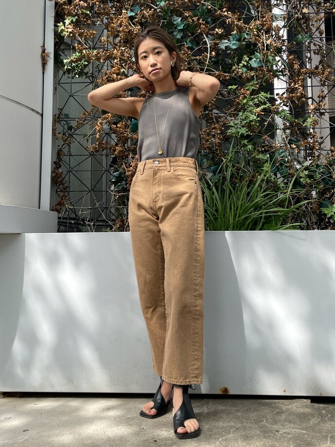 ブラック系のサンダル、ベージュ系のデニムパンツ、グリーン系のTシャツ/カットソーを着用したレディースの春コーディネートの3枚目の写真