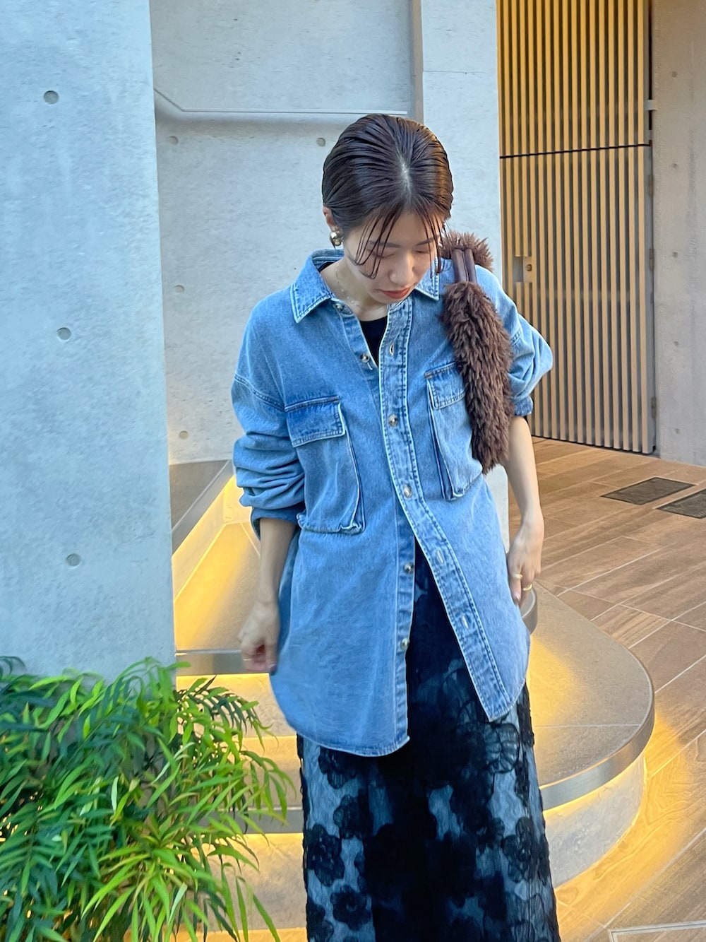 ブルー系のシャツ/ブラウス、ブラック系のスカートを着用したレディースの秋コーディネートの2枚目の写真