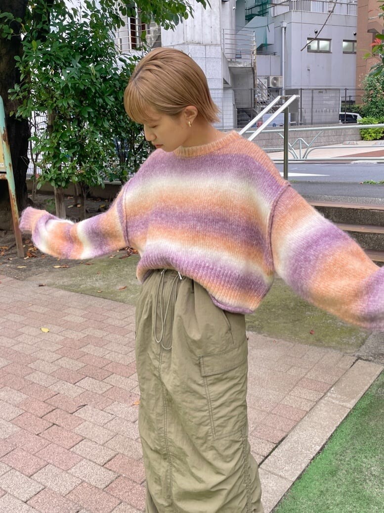 グリーン系のスカート、ピンク系のニット/セーターを着用したレディースの秋コーディネートの4枚目の写真