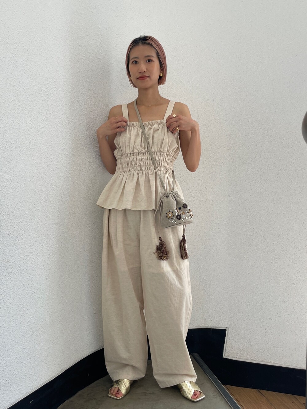 ホワイト系のキャミソール、ホワイト系のその他パンツ、ブラック系のハンドバッグを着用したレディースの夏コーディネートの2枚目の写真