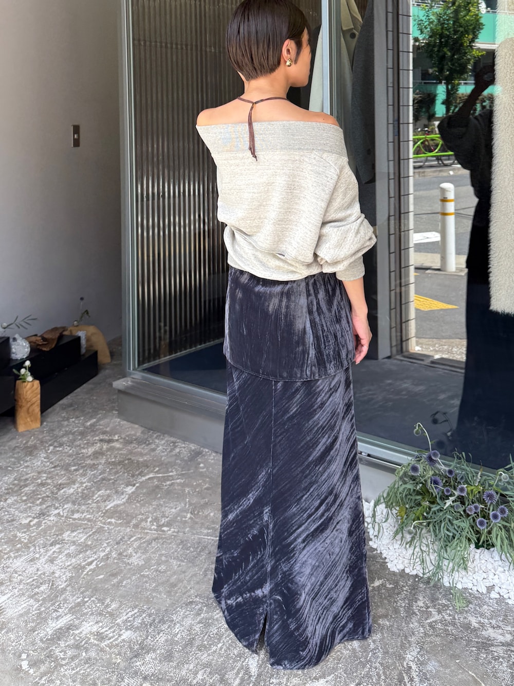 グレー系のスウェット、ブラック系のスカート、ゴールド系のネックレスを着用したレディースの夏コーディネートの5枚目の写真