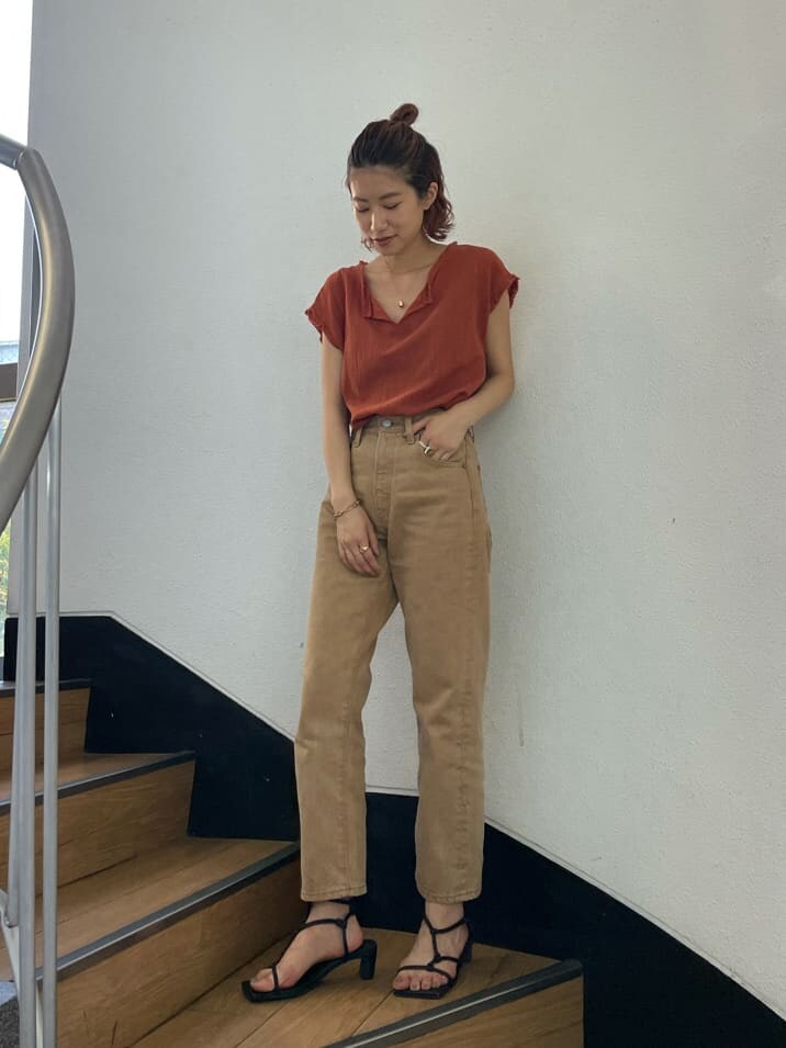 オレンジ系のシャツ/ブラウス、ベージュ系のデニムパンツを着用したレディースの夏コーディネートの3枚目の写真