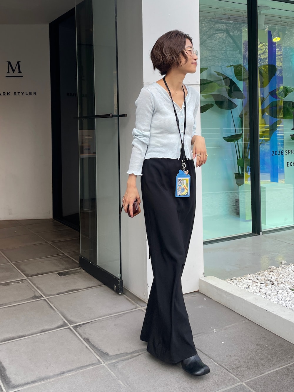 ブルー系のカーディガン/ボレロ、ブラック系のスカートを着用したレディースの春コーディネートの2枚目の写真