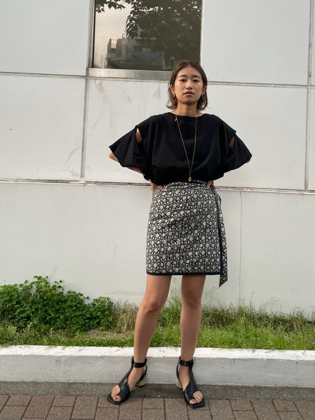 ブラック系のサンダル、ブラック系のTシャツ/カットソー、ブルー系のスカートを着用したレディースの春コーディネートの2枚目の写真