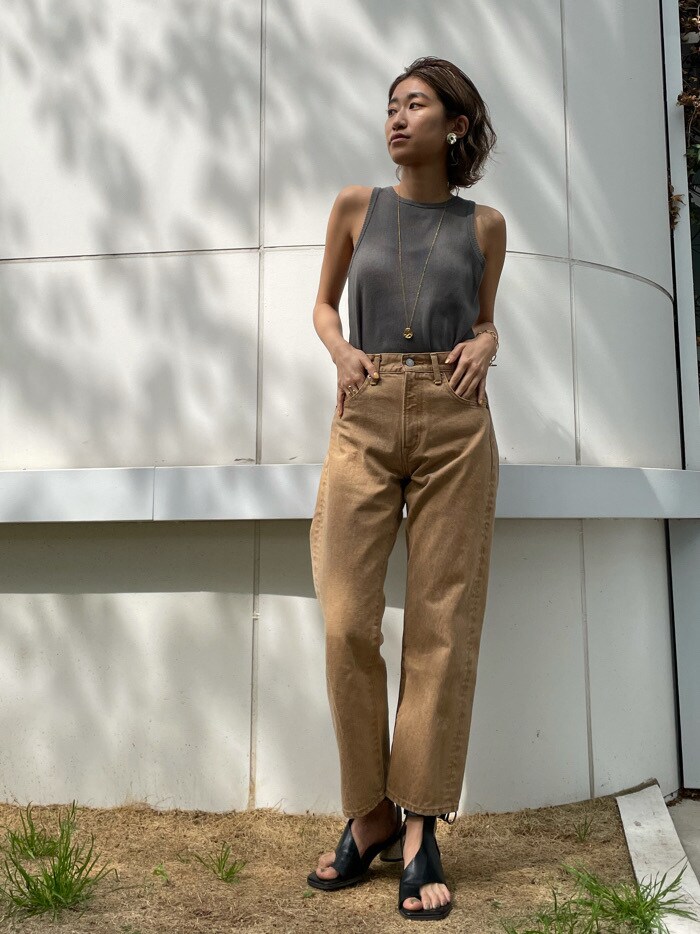 ブラック系のサンダル、ベージュ系のデニムパンツ、グリーン系のTシャツ/カットソーを着用したレディースの春コーディネートの2枚目の写真