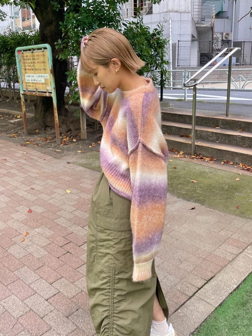 グリーン系のスカート、ピンク系のニット/セーターを着用したレディースの秋コーディネートの3枚目の写真