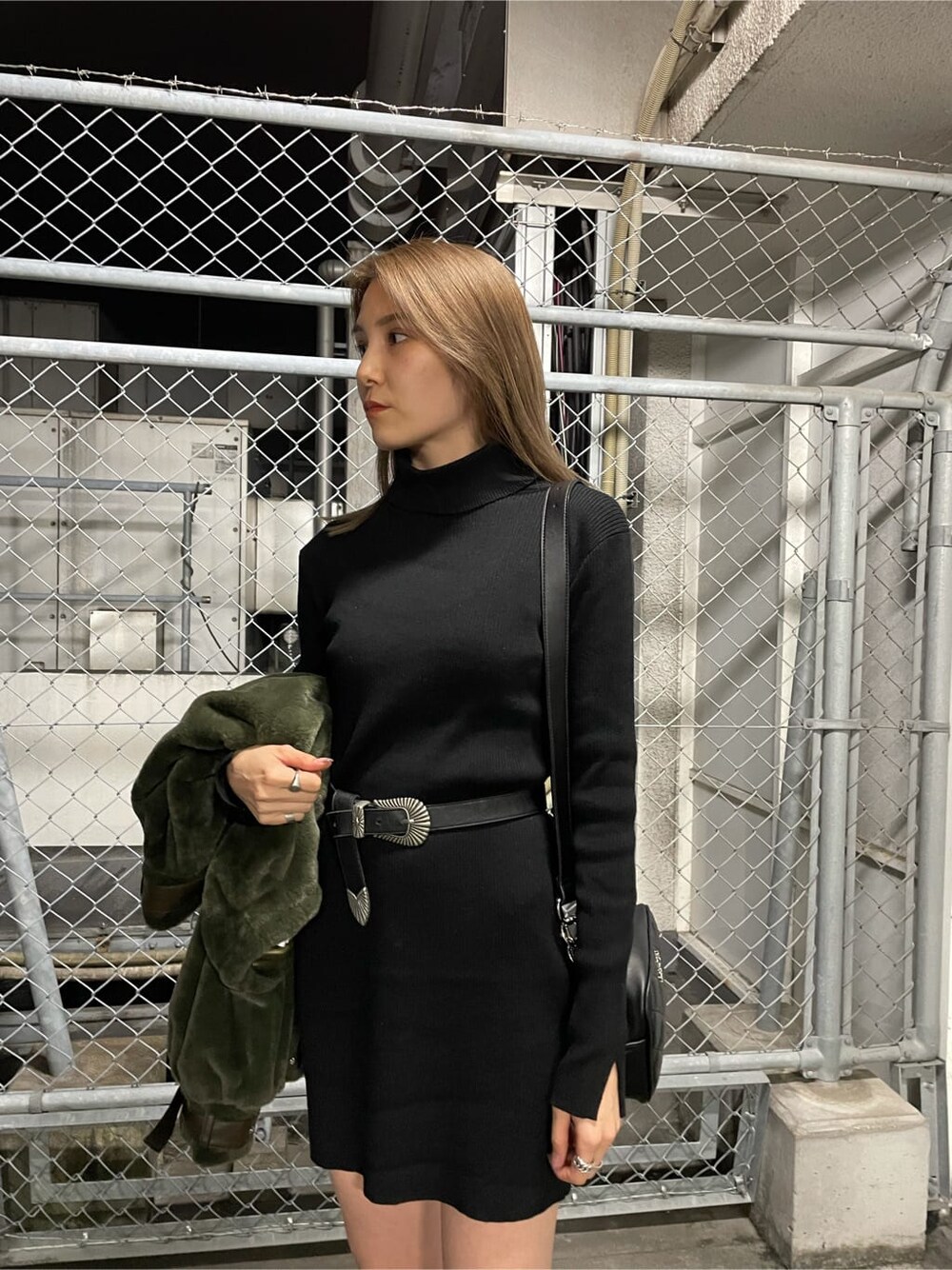 ブラック系のワンピース、ベージュ系のブルゾン、ブラック系のブーツを着用したレディースの秋コーディネートの3枚目の写真