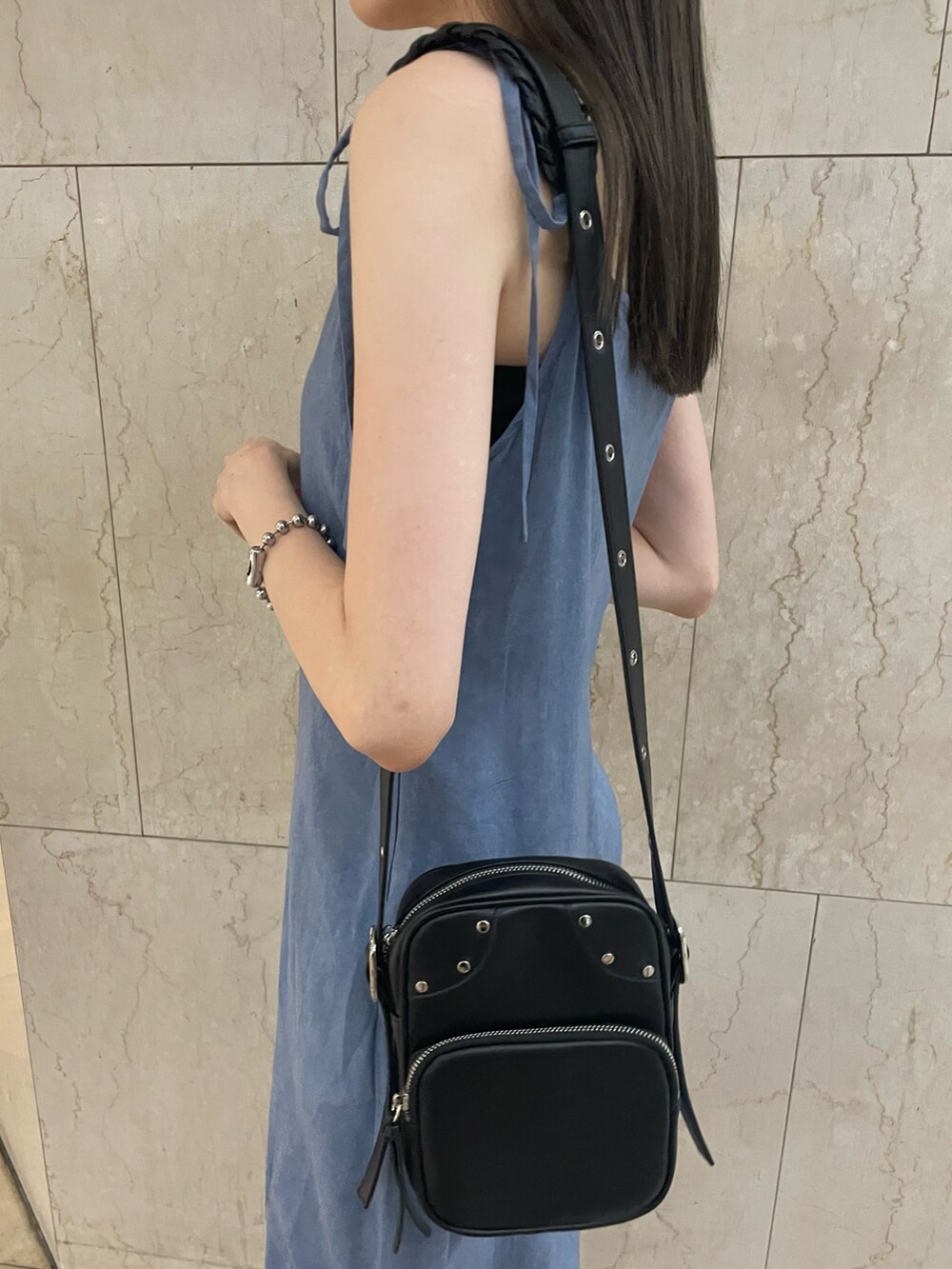 ブルー系のワンピース、ブラック系のショルダーバッグ、ブラック系のブーツを着用したレディースの夏コーディネートの8枚目の写真