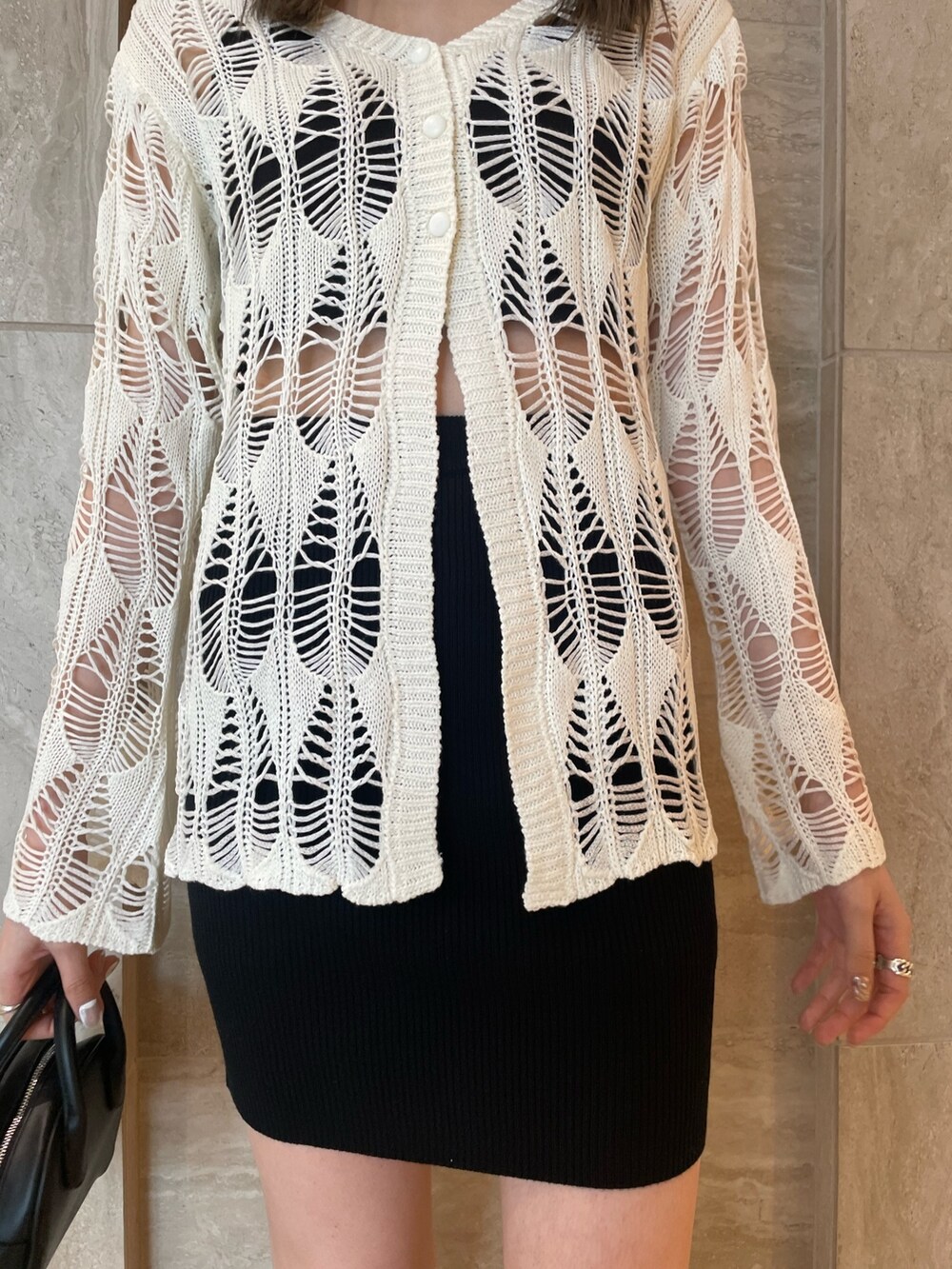 ホワイト系のカーディガン/ボレロ、ブラック系のキャミソール、ブラック系のスカートを着用したレディースの春コーディネートの5枚目の写真