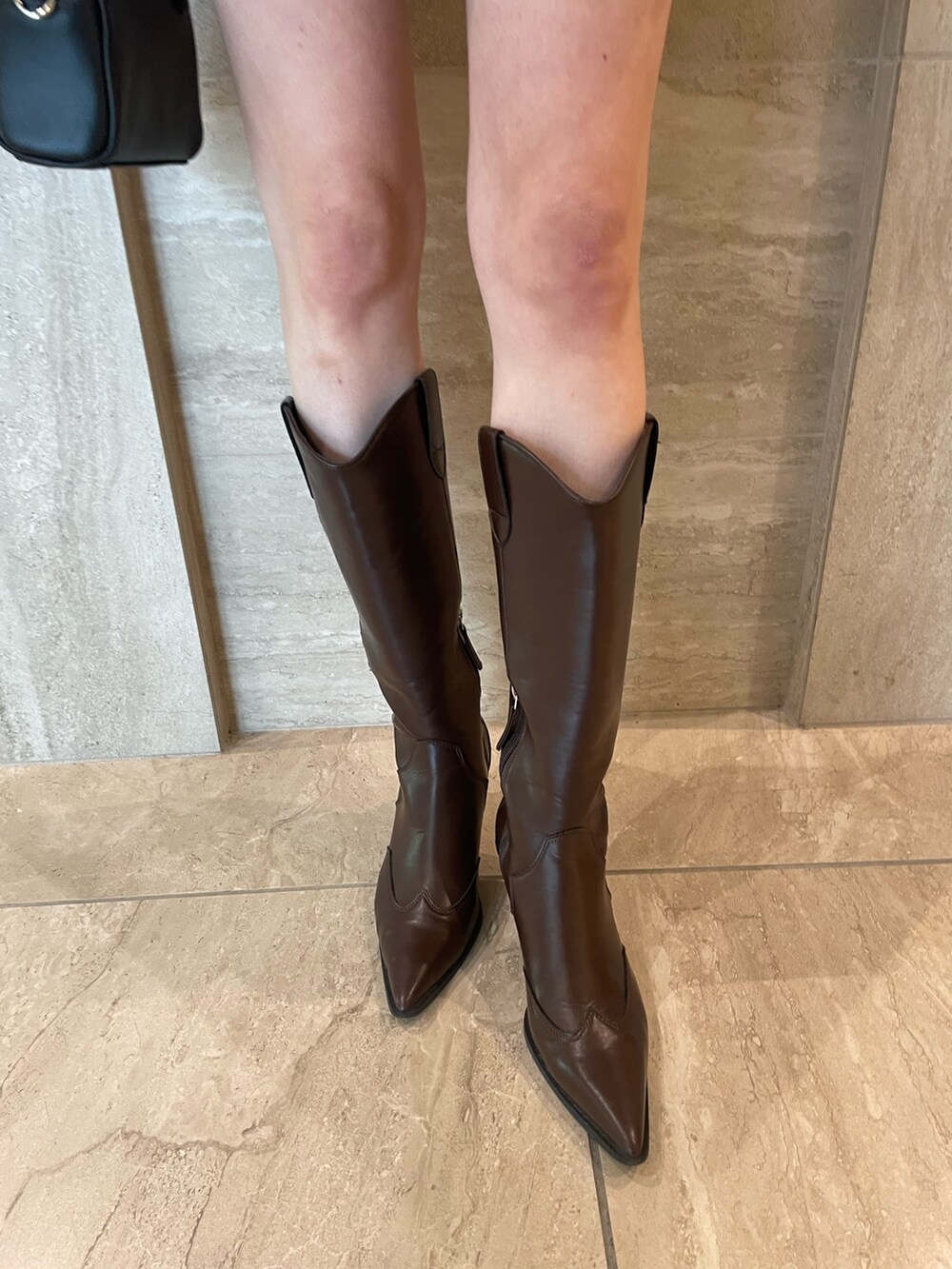 ホワイト系のカーディガン/ボレロ、ブラック系のキャミソール、ブラック系のスカートを着用したレディースの春コーディネートの6枚目の写真