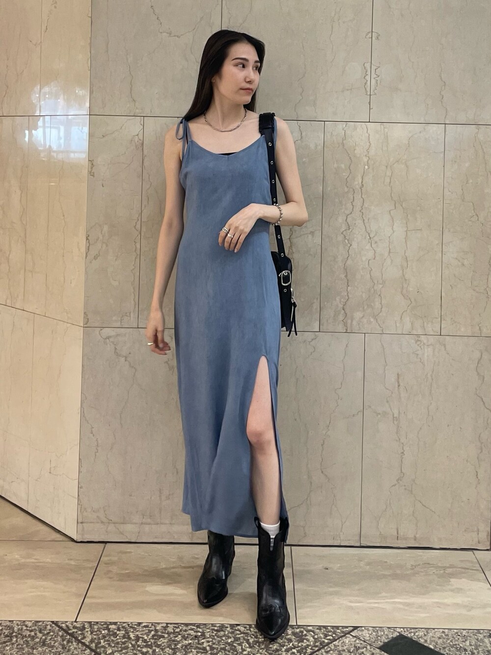 ブルー系のワンピース、ブラック系のショルダーバッグ、ブラック系のブーツを着用したレディースの夏コーディネートの2枚目の写真