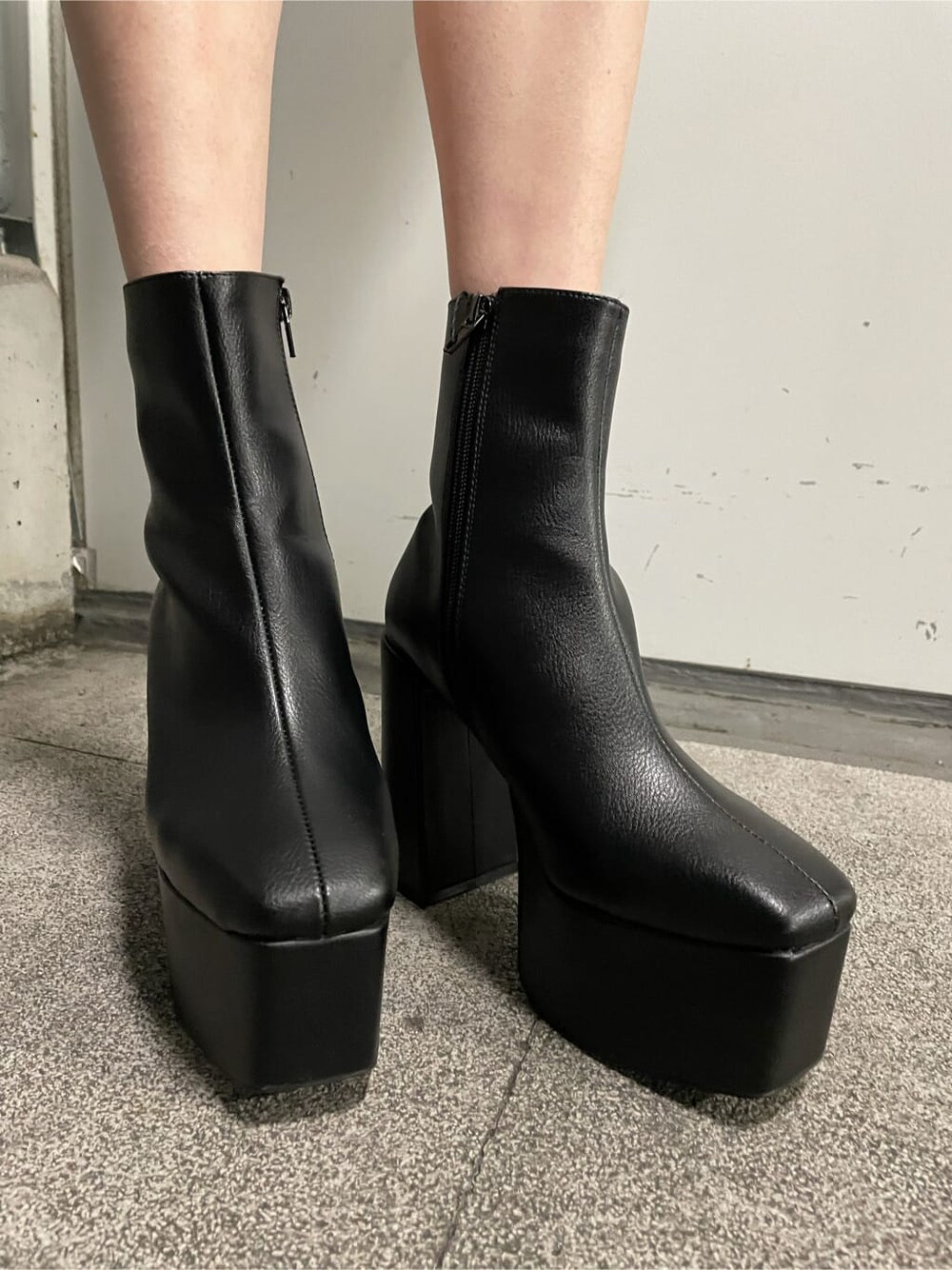 ブラック系のワンピース、ベージュ系のブルゾン、ブラック系のブーツを着用したレディースの秋コーディネートの6枚目の写真