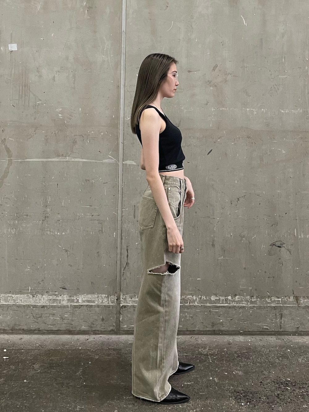 ブラック系のブーツ、ベージュ系のデニムパンツ、その他のサングラスを着用したレディースの夏コーディネートの2枚目の写真