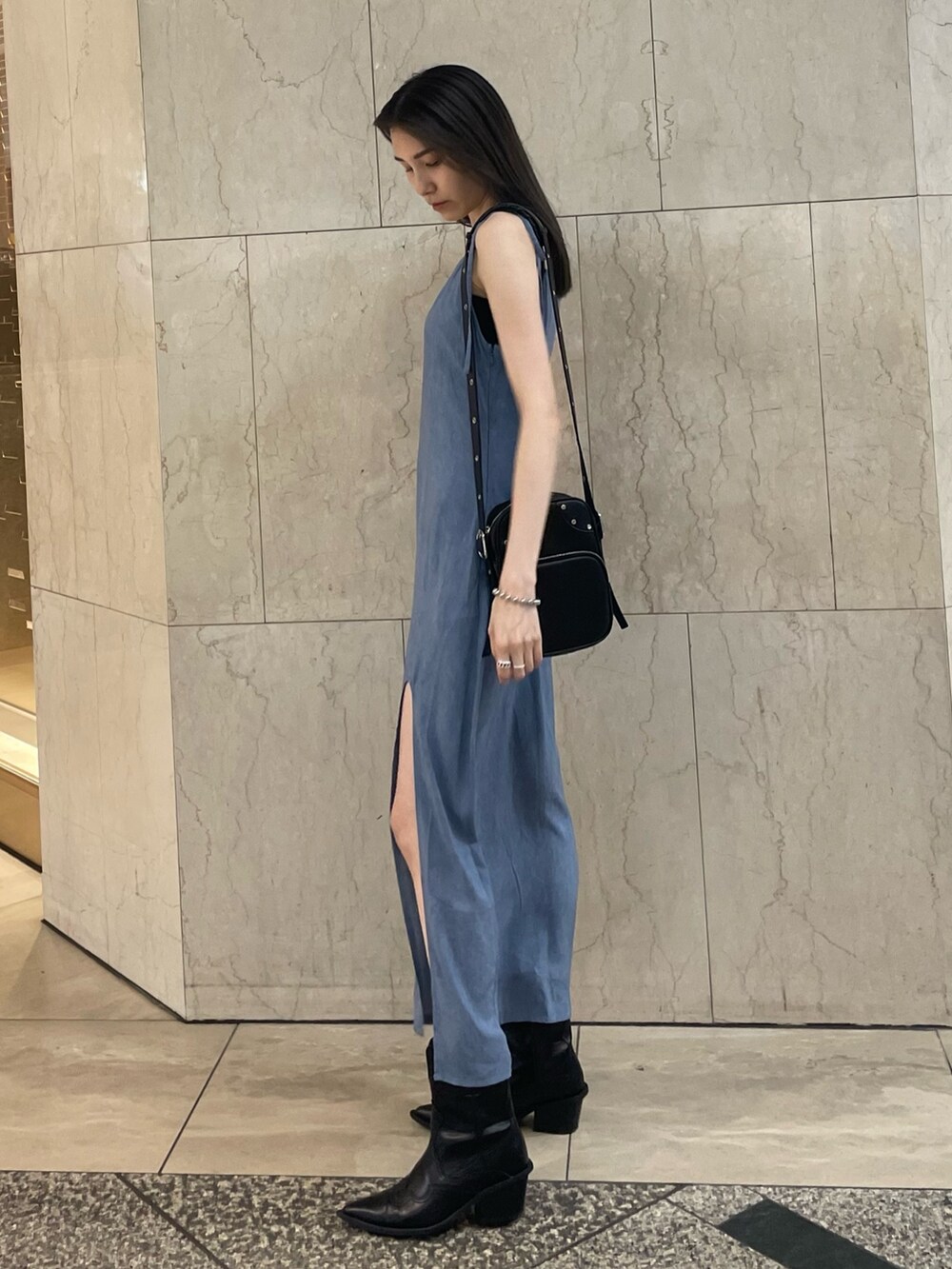 ブルー系のワンピース、ブラック系のショルダーバッグ、ブラック系のブーツを着用したレディースの夏コーディネートの3枚目の写真