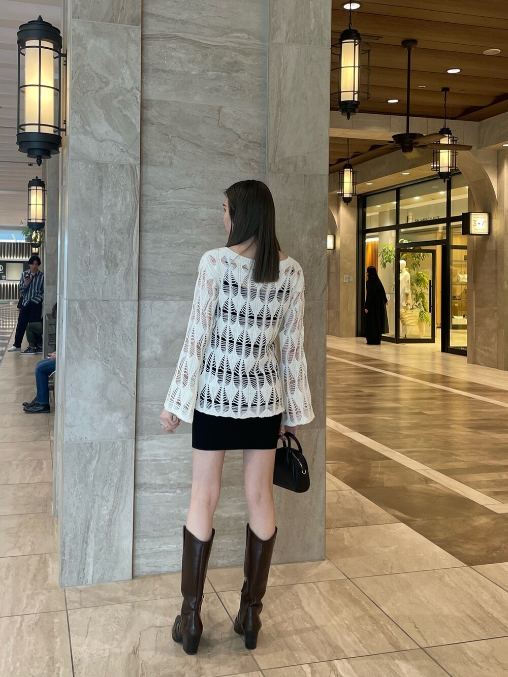 ホワイト系のカーディガン/ボレロ、ブラック系のキャミソール、ブラック系のスカートを着用したレディースの春コーディネートの3枚目の写真