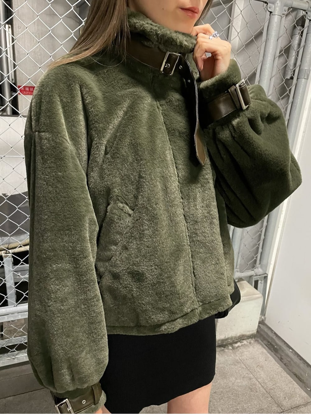 ブラック系のワンピース、ベージュ系のブルゾン、ブラック系のブーツを着用したレディースの秋コーディネートの4枚目の写真