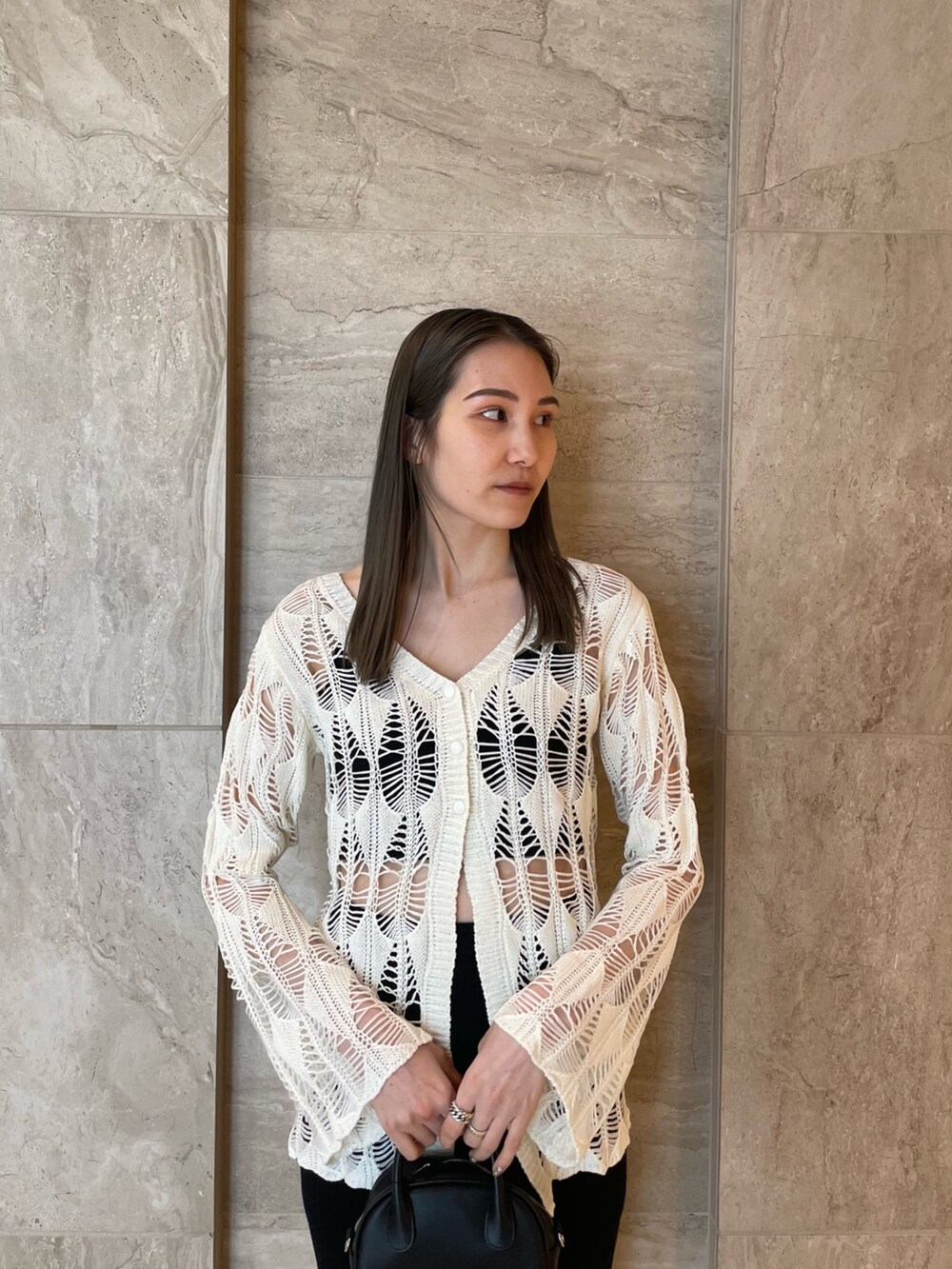 ホワイト系のカーディガン/ボレロ、ブラック系のキャミソール、ブラック系のスカートを着用したレディースの春コーディネートの4枚目の写真