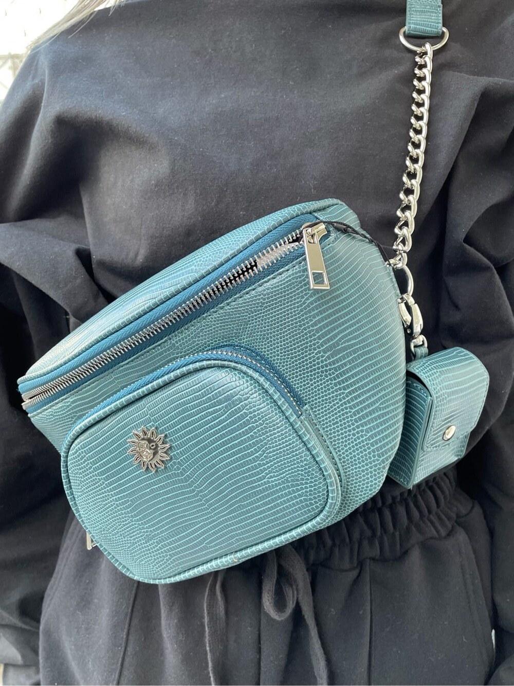 ブラック系のスウェットパンツ、ブラック系のブーツ、ブルー系のボディバッグ/ウエストポーチを着用したレディースの冬コーディネートの5枚目の写真