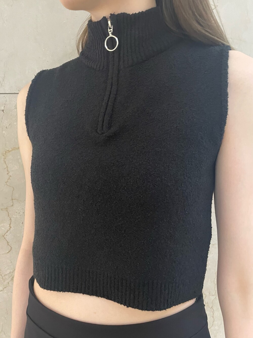 グリーン系のタンクトップ、ブラック系のスカート、ブラック系のブーツを着用したレディースの春コーディネートの6枚目の写真