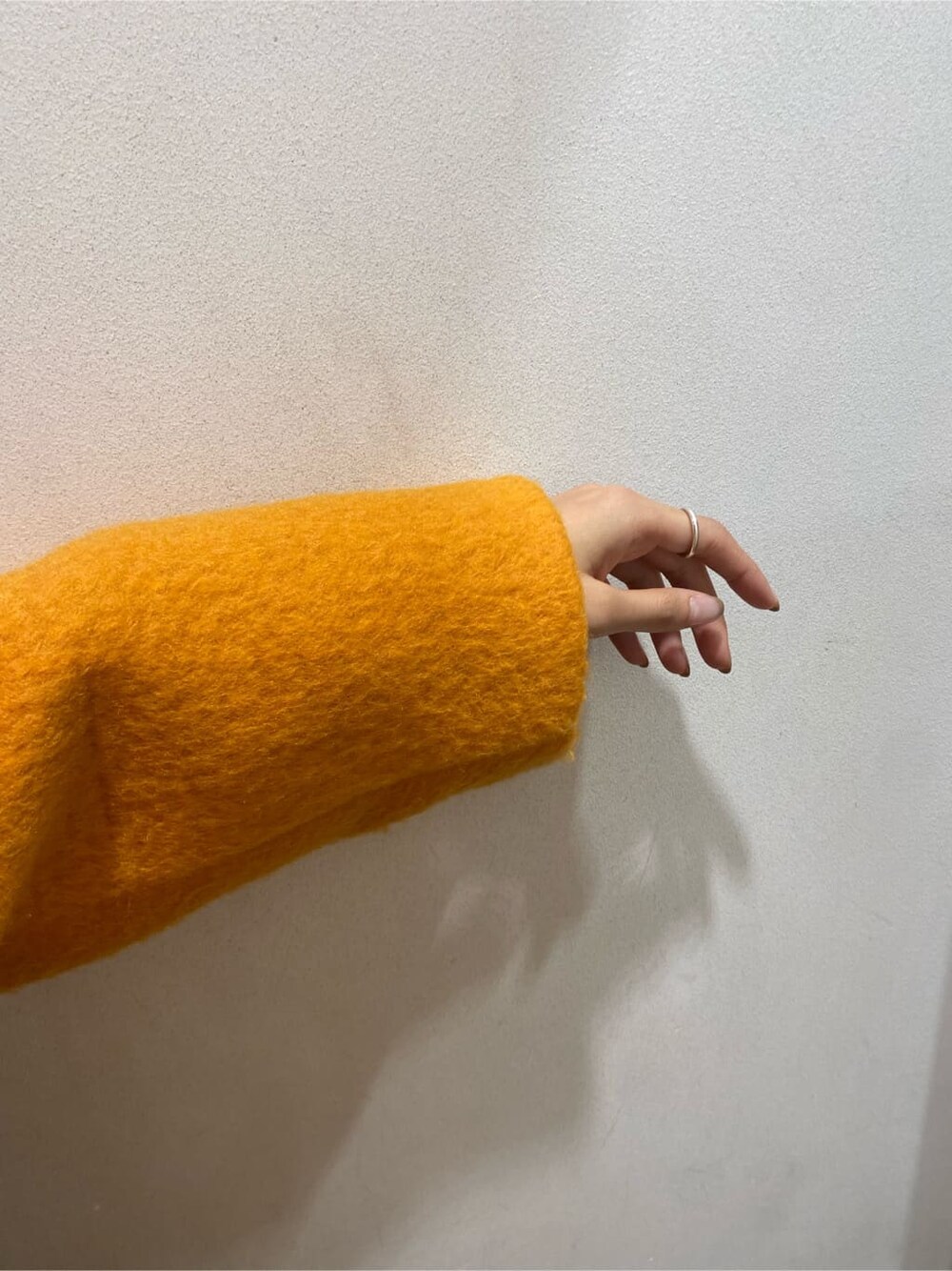 イエロー系のテーラードジャケット、ブラウン系のブーツ、ブルー系のデニムパンツを着用したレディースの秋コーディネートの8枚目の写真