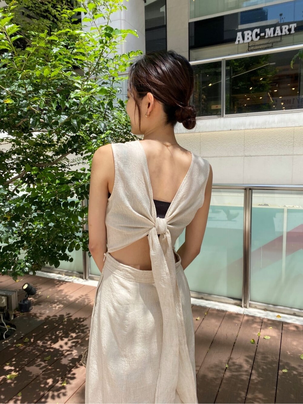 ベージュ系のかごバッグ、ホワイト系のワンピースを着用したレディースの春コーディネートの4枚目の写真