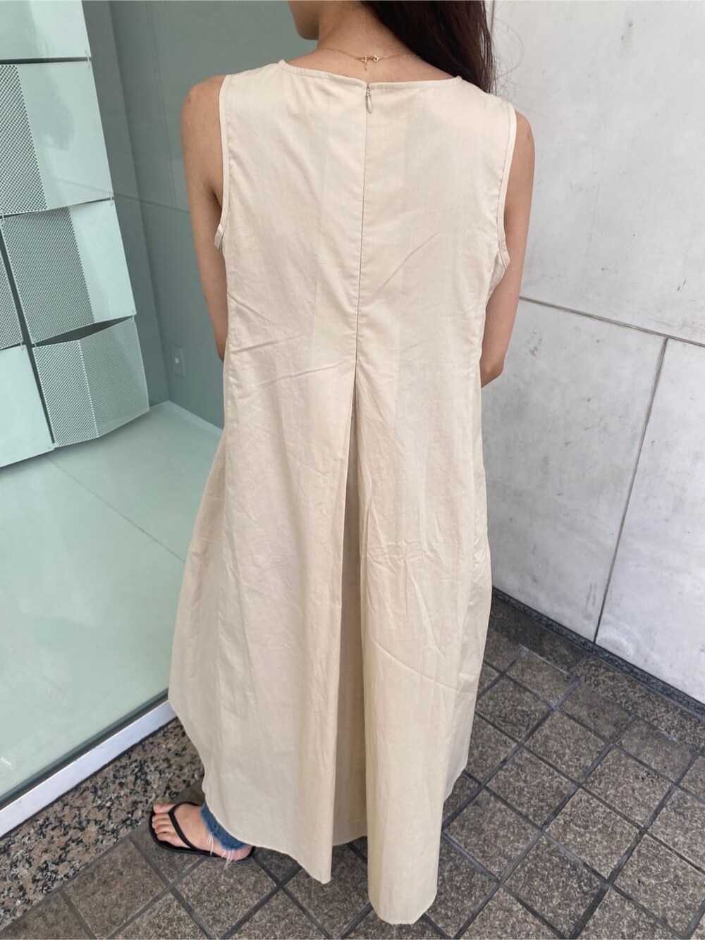 ブルー系のデニムパンツ、ベージュ系のワンピースを着用したレディースの春コーディネートの4枚目の写真