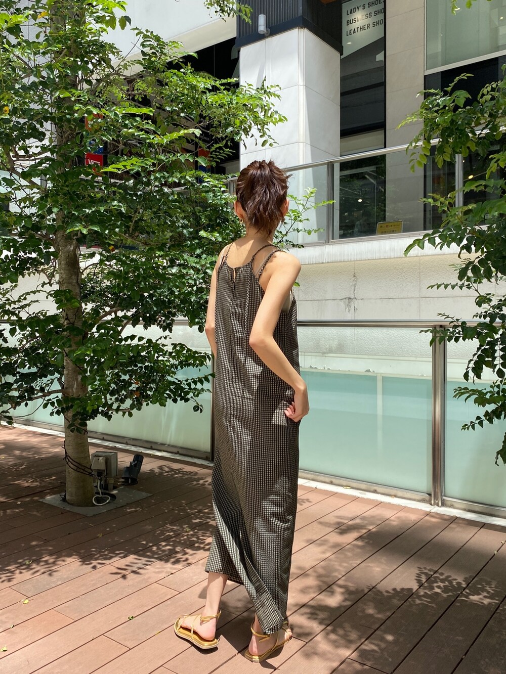 ベージュ系のワンピース、ゴールド系のサンダルを着用したレディースの春コーディネートの3枚目の写真